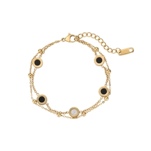 Détail macro du bracelet double couche en acier inoxydable doré avec pendentifs