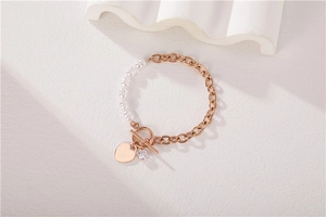 Detail of rose gold OT buckle bracelet with white pearls and heart pendant