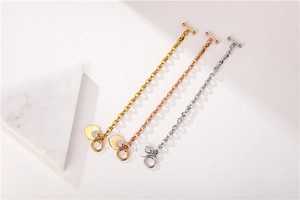 Close-up of heart pendants and toggle clasp on gold, rose gold, and silver chain bracelets