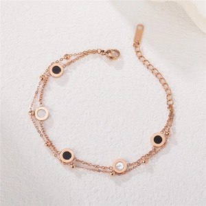 Bracelet double rang en titane or rose avec charms disques en nacre noire et blanche