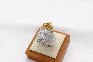 Détail en relief d'une bague lion vintage avec couronne dorée et acier argenté