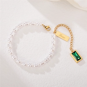 Elegant pearl bracelet with gold chain, green gemstone pendant, and Love engraved charm