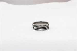 Détail d'une bague vintage en acier titane avec texture tressée triple rang et fini antique