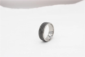Détails macro de la bague rétro en acier titane avec trois rangées de points et fini vieilli