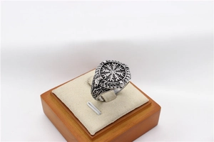 Macro shot of vintage Viking steel ring featuring Helm of Awe and skull engravings