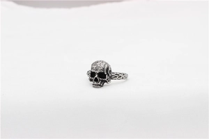 Detailed view of vintage silver skull ring with textured hammered stainless steel band