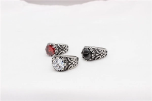 Detailed view of three vintage steel rings with red, white, and black oval gemstones
