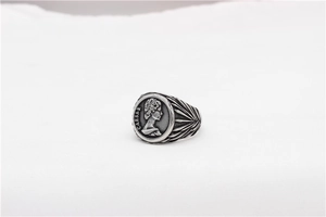 Detail of vintage silver signet ring with Caesar coin relief and feather wing texture