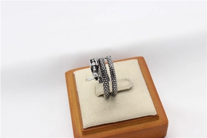 Close-up of vintage steel dragon ring showing intricate scales on a wooden stand
