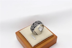 Detailed close-up of retro Viking Valknut triangle patterns on a men's steel ring