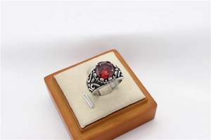 Detail shot of vintage men's ring with red gemstone and floral relief engraving