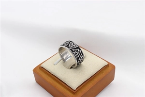 Macro detail of vintage Viking Valknut symbol engraved on wide stainless steel ring