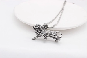 Detailed view of a vintage silver lion pendant necklace showing fine mane carvings and textures