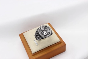 Macro shot of retro silver coin signet ring featuring Caesar profile and radial carvings
