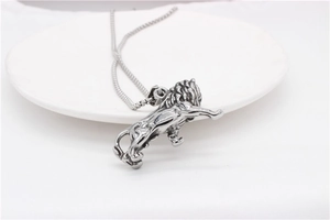 Detailed close-up of a silver lion pendant featuring vintage blackened steel textures