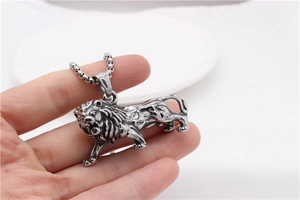 Detail of vintage lion pendant necklace in silver stainless steel held in hand