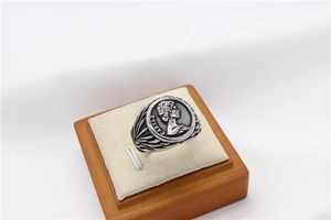 Detail shot of vintage silver Caesar coin relief ring with engraved feather texture