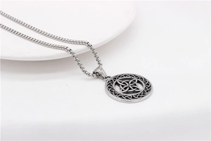 Close-up of silver Viking Celtic Knot pendant necklace on a clean white ceramic plate