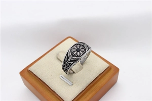 Bague compas viking avec pierre noire et nœuds celtiques sur boîte en bois, macro
