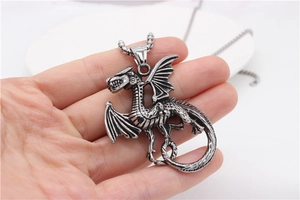 Detailed close-up of retro dragon pendant in hand showing intricate vintage steel scales