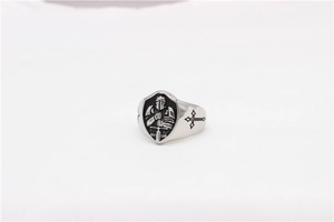 Macro view of medieval knight shield relief and vintage cross on steel ring band