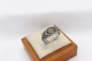 Détail macro de bague boussole Viking vintage avec nœuds nordiques et motifs d'oiseaux