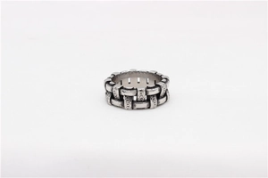 Close-up of vintage silver steel ring featuring intricate woven texture and floral carvings
