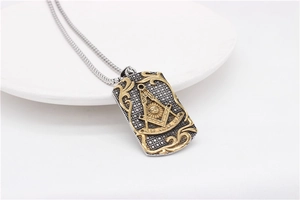 Macro view of bicolor Freemason square and compass pendant on a polished bead chain