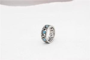 Detailed macro view of retro wide band ring with turquoise stones and Celtic knotwork