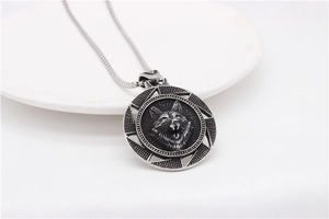 Vue détaillée du pendentif loup argenté vintage sur une assiette en céramique