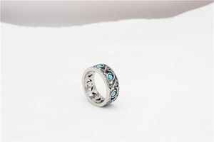 Detailed view of silver vintage ring featuring turquoise stones and intricate vine carvings