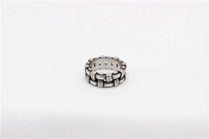 Macro detail of retro chain ring with intricate vine engravings and oxidized silver finish