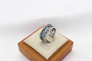 Detail of vintage filigree stainless steel ring set with turquoise blue gemstones