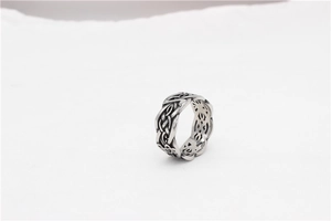 Macro detail of vintage silver Viking ring featuring intricate Celtic knot hollow patterns