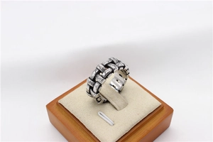 Detailed macro view of vintage silver braided steel ring with oxidized finish on display stand