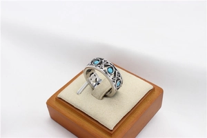 Close-up of vintage stainless steel ring featuring Celtic knot carvings and blue turquoise