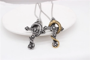 Detail of gothic dragon and skull cross pendants in vintage silver and gold finish