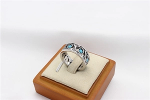 Detailed view of bohemian hollow engraved ring with three turquoise stones on a display