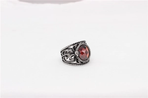 Détail d'une bague gothique argentée avec motifs ajourés et une grande pierre rouge