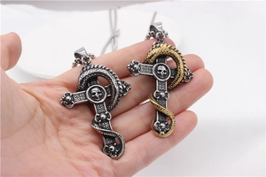 Close-up of gothic dragon cross necklaces with skull details in silver and gold finish