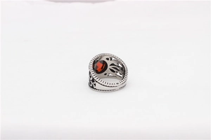 Gros plan détaillé sur bague rétro en acier avec pierre rouge ovale et motifs évidés