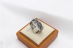 Detail view of vintage Viking steel ring with note patterns on a wooden display stand