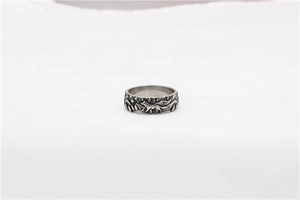 Close-up of vintage wolf and pine forest engraving on a men's stainless steel ring