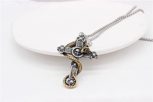 Close-up of vintage punk dragon cross pendant with skull relief on stainless steel chain