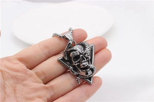Macro shot of gothic punk snake wrapped around a skull pendant in retro silver finish