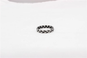Detailed macro shot of vintage Viking steel ring with braided rope texture design