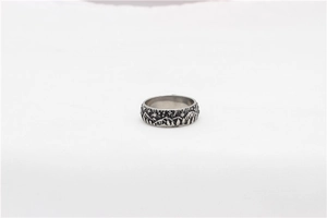Detail of vintage wolf steel ring showing embossed mountain and forest texture