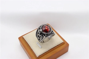 Détail d'une bague vintage en argent avec gravures précises et pierre rouge