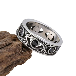 Vintage silver steel ring with Celtic knot pattern and black stones on bark