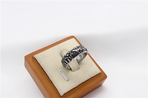 Macro shot of retro steel wolf ring with embossed forest and starry sky details